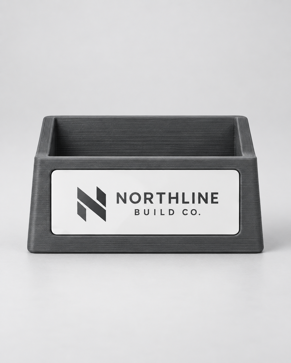 Illustrative business mockup. Charcoal business card holder with Northline Build Co. logo plate