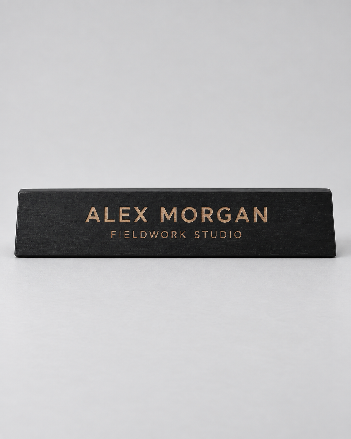 Illustrative business mockup. Black wooden Alex Morgan desk nameplate with tan engraving