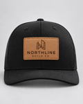 Illustrative business mockup. Black Richardson 112 hat with an engraved tan Northline Build Co. leather patch