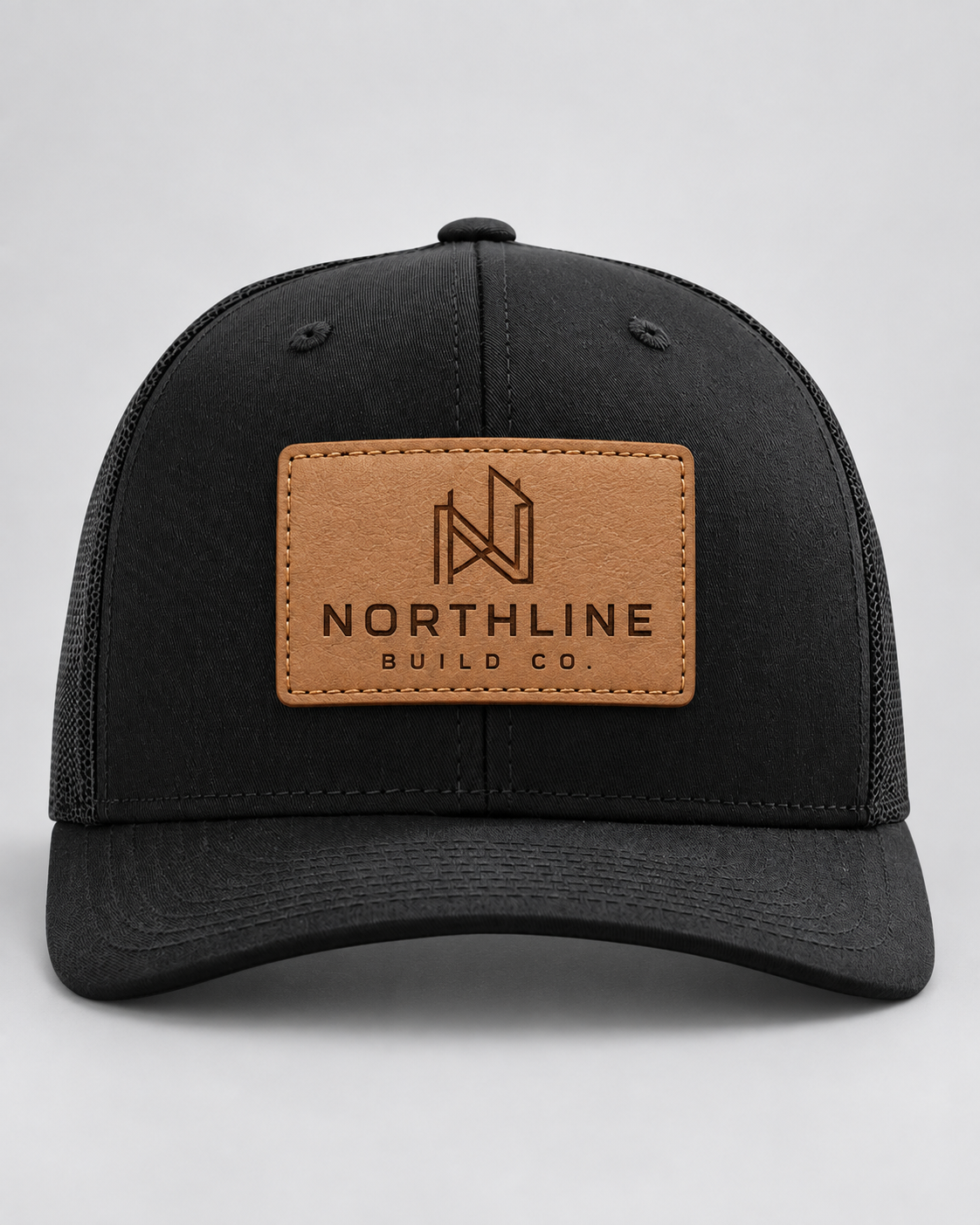 Illustrative business mockup. Black Richardson 112 hat with an engraved tan Northline Build Co. leather patch