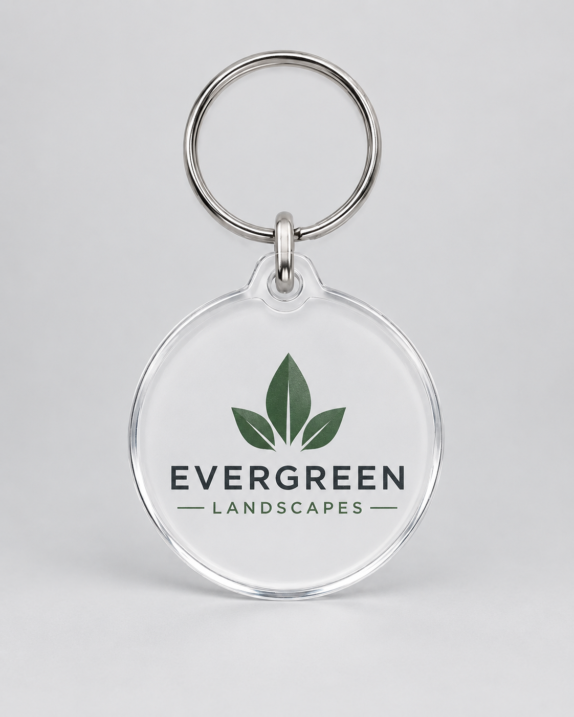 Illustrative business mockup. Clear acrylic keychain with Evergreen Landscapes logo