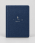 Illustrative business mockup. Navy notebook with cream Fieldwork Studio cover logo