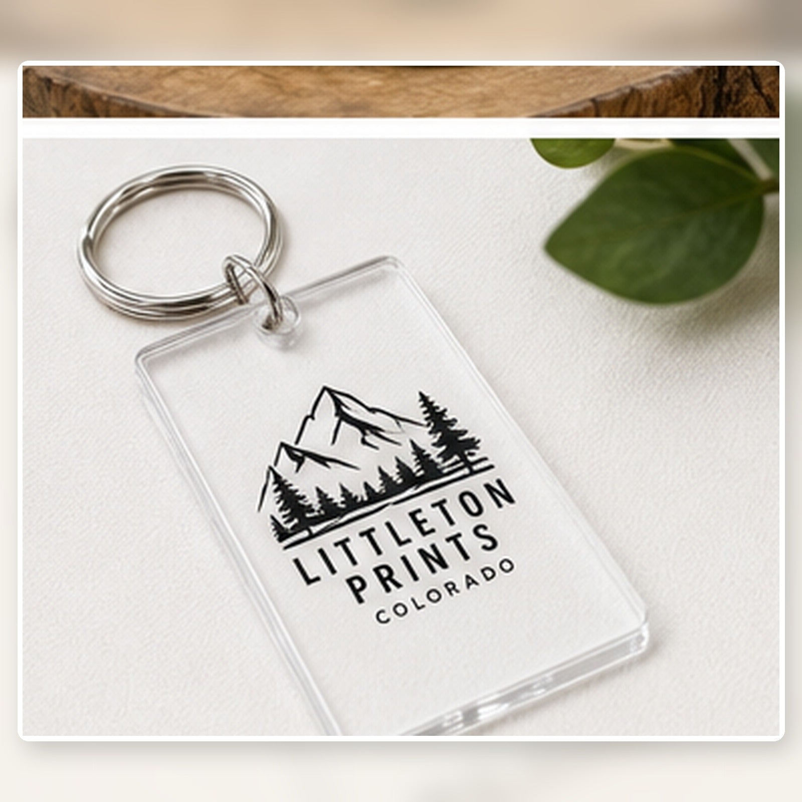 UV printed acrylic keychain tag with sample Littleton artwork on a bright studio background sample image