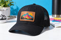 Black trucker cap with a full-color UV printed leather patch — illustrative concept